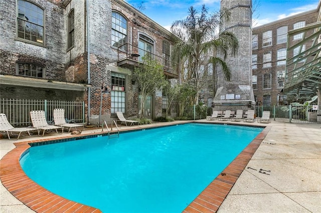 pool with fence and a patio area