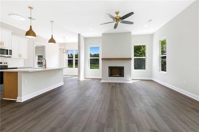 35378 Liberty Dr, Slidell, LA 70460 - unfurnished living room featuring dark wood finished floors, ceiling fan, baseboards, a fireplace with flush hearth, and recessed lighting
