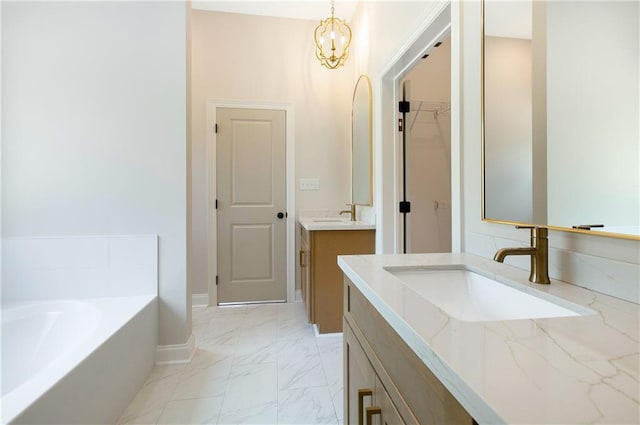 35378 Liberty Dr, Slidell, LA 70460 - bathroom featuring marble look tiles, a garden tub, two vanities, a chandelier, and baseboards
