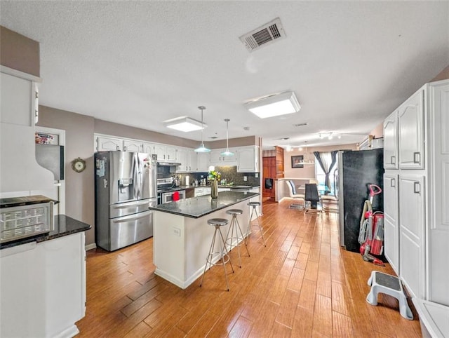 632 Fairlawn Dr, Terrytown, LA 70056 - kitchen with visible vents, stainless steel appliances, light wood-style floors, and dark countertops