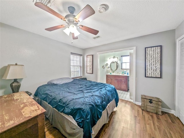 632 Fairlawn Dr, Terrytown, LA 70056 - bedroom with baseboards, a textured ceiling, visible vents, ensuite bathroom, and wood finished floors
