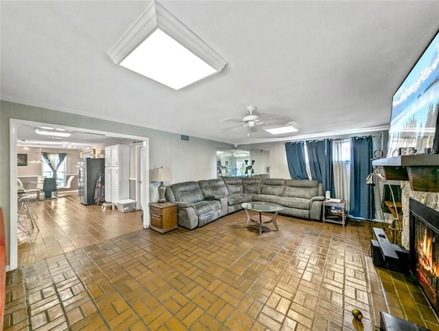 632 Fairlawn Dr, Terrytown, LA 70056 - living room with ceiling fan, brick floor, crown molding, and a stone fireplace