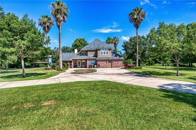 view of front of home with driveway, a front yard, and a garage
