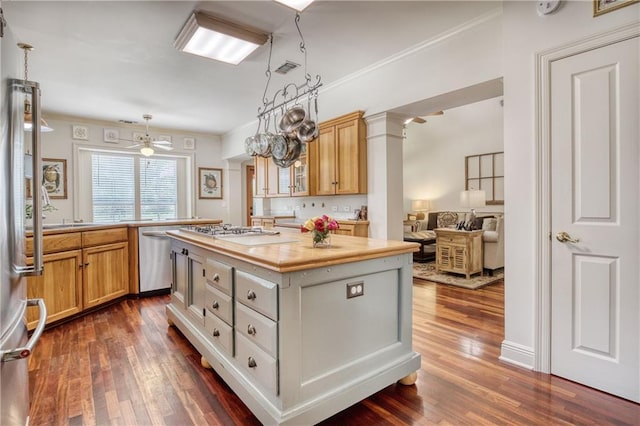 kitchen featuring light countertops, ornamental molding, stainless steel appliances, dark wood-type flooring, and a center island
