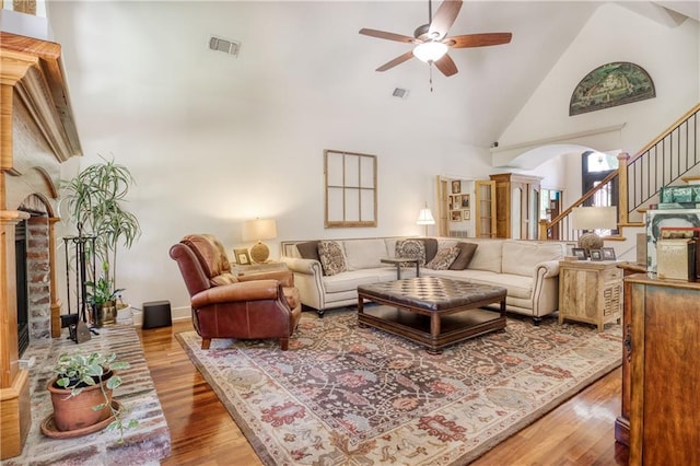 living area featuring wood finished floors, high vaulted ceiling, ceiling fan, and visible vents