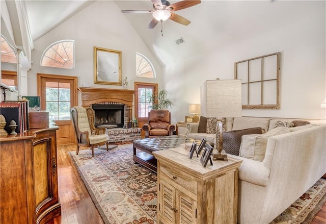living room with wood-type flooring, plenty of natural light, a fireplace, and ceiling fan