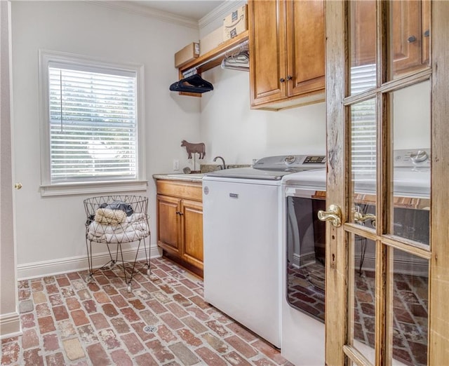 clothes washing area featuring washing machine and dryer, brick floor, baseboards, cabinet space, and ornamental molding