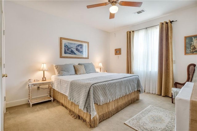 bedroom with visible vents, a ceiling fan, and light carpet