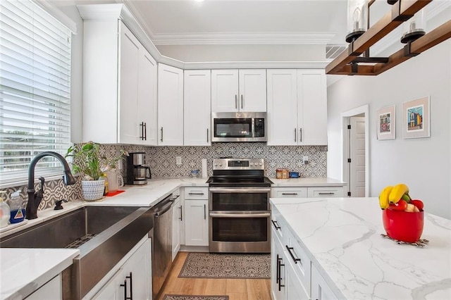 441 Hancock St, Gretna, LA 70053 - kitchen featuring white cabinetry, ornamental molding, decorative backsplash, a sink, and appliances with stainless steel finishes
