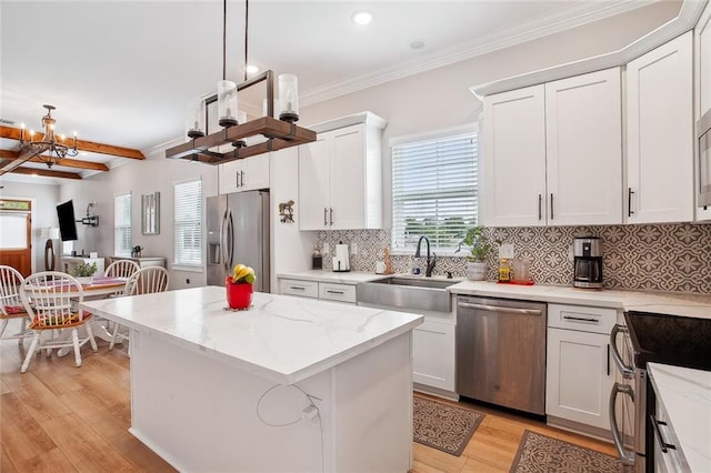 441 Hancock St, Gretna, LA 70053 - kitchen with crown molding, light wood-style flooring, stainless steel appliances, a center island, and white cabinets