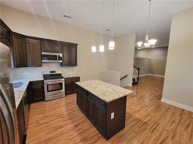 305 Amapola Cir, Terrytown, LA 70056 - kitchen featuring stainless steel appliances, light wood-style flooring, a kitchen island, a chandelier, and dark brown cabinets