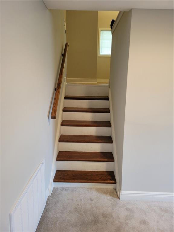 staircase featuring baseboards, carpet flooring, and visible vents