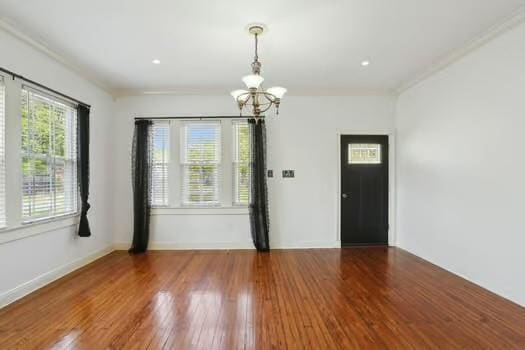 4674 Venus St, New Orleans, LA 70122 - spare room with a chandelier, ornamental molding, and wood finished floors