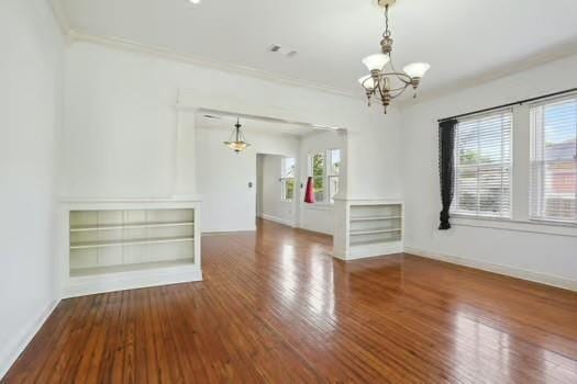 4674 Venus St, New Orleans, LA 70122 - spare room featuring a chandelier, wood finished floors, and crown molding