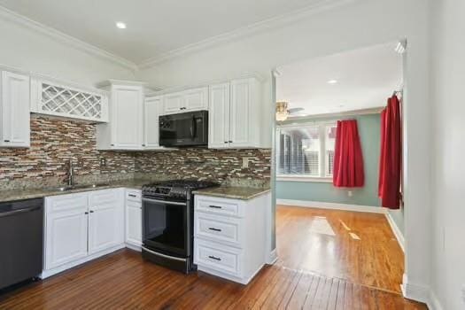 4674 Venus St, New Orleans, LA 70122 - kitchen featuring black microwave, gas range oven, dishwasher, white cabinetry, and dark wood finished floors