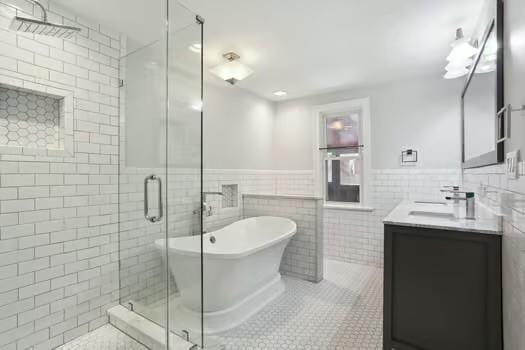 4674 Venus St, New Orleans, LA 70122 - full bathroom featuring tile walls, tile patterned floors, vanity, a soaking tub, and a stall shower