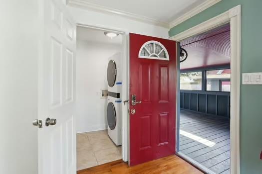 4674 Venus St, New Orleans, LA 70122 - entryway with stacked washer / dryer, crown molding, and wood finished floors