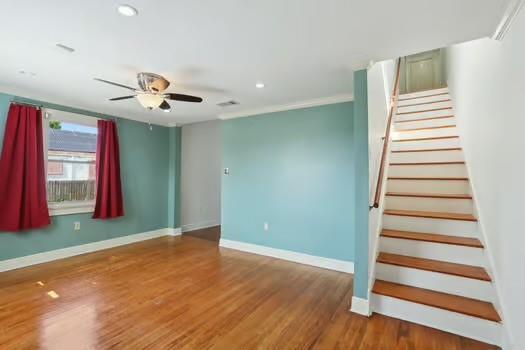 4674 Venus St, New Orleans, LA 70122 - empty room with stairs, wood finished floors, a ceiling fan, and recessed lighting