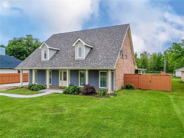 cape cod house featuring roof with shingles, covered porch, fence, and a front lawn