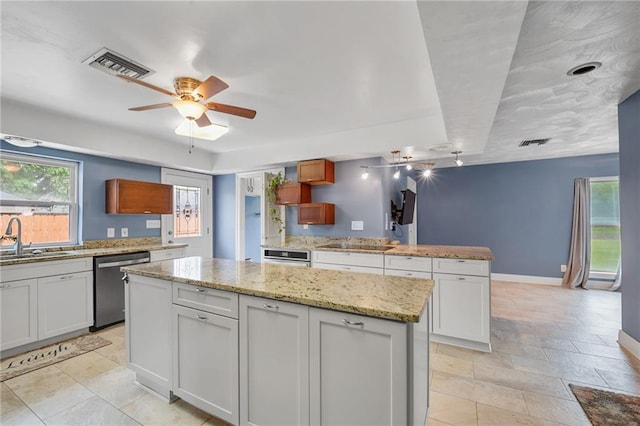 kitchen featuring a sink, visible vents, stainless steel dishwasher, and a center island