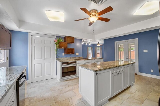 212 Somerset St, La Place, LA 70068 - kitchen with appliances with stainless steel finishes, a ceiling fan, a peninsula, a center island, and light stone counters