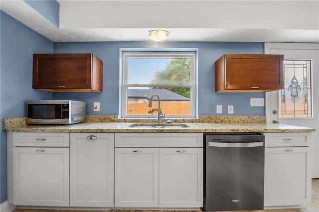 212 Somerset St, La Place, LA 70068 - kitchen featuring appliances with stainless steel finishes, a sink, light stone countertops, and white cabinetry