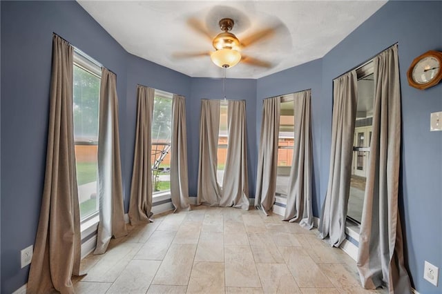 unfurnished room featuring baseboards and ceiling fan
