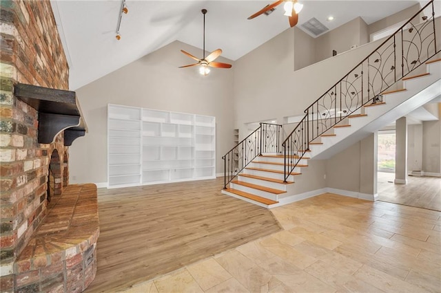 212 Somerset St, La Place, LA 70068 - unfurnished living room featuring a ceiling fan, stairs, high vaulted ceiling, baseboards, and a fireplace