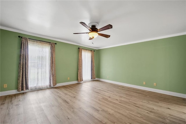 spare room with crown molding, wood finished floors, ceiling fan, and a wealth of natural light