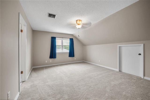 bonus room featuring ceiling fan, a textured ceiling, vaulted ceiling, visible vents, and carpet floors