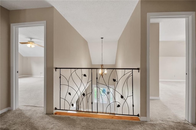 interior space with carpet floors, baseboards, and ceiling fan with notable chandelier