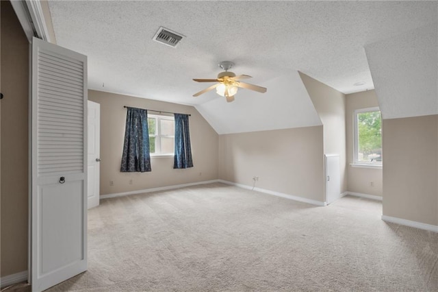 bonus room featuring visible vents, ceiling fan, light colored carpet, and baseboards