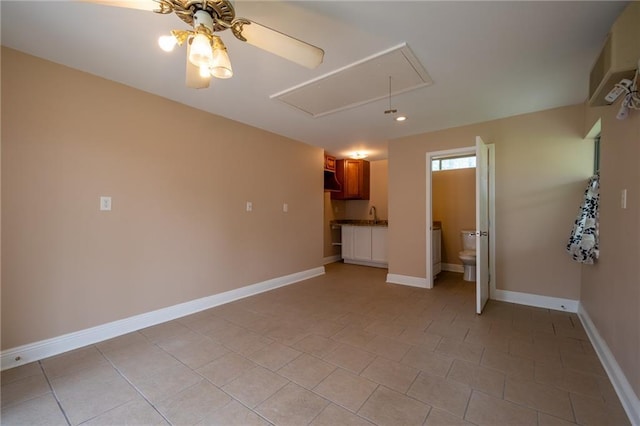 unfurnished living room featuring baseboards, recessed lighting, light tile patterned floors, attic access, and a ceiling fan