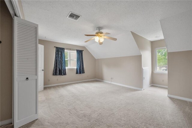 212 Somerset St, La Place, LA 70068 - additional living space with a ceiling fan, baseboards, light carpet, a textured ceiling, and vaulted ceiling