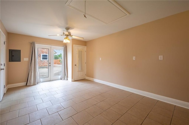 empty room with baseboards, electric panel, attic access, light tile patterned flooring, and ceiling fan