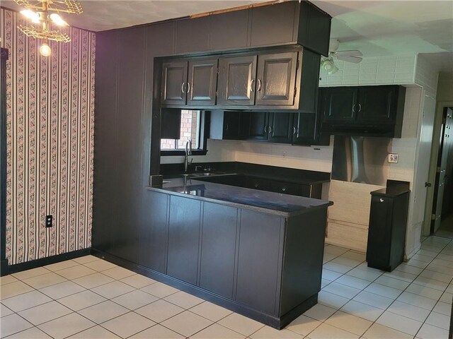 2745 Phil Ln, Marrero, LA 70072 - kitchen featuring a sink, dark countertops, ceiling fan, a peninsula, and light tile patterned floors