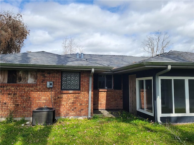 2745 Phil Ln, Marrero, LA 70072 - view of side of home featuring cooling unit, a sunroom, brick siding, a shingled roof, and a yard