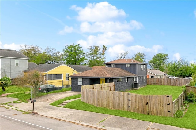 view of front of house featuring a gate, central AC unit, concrete driveway, a front yard, and a fenced front yard