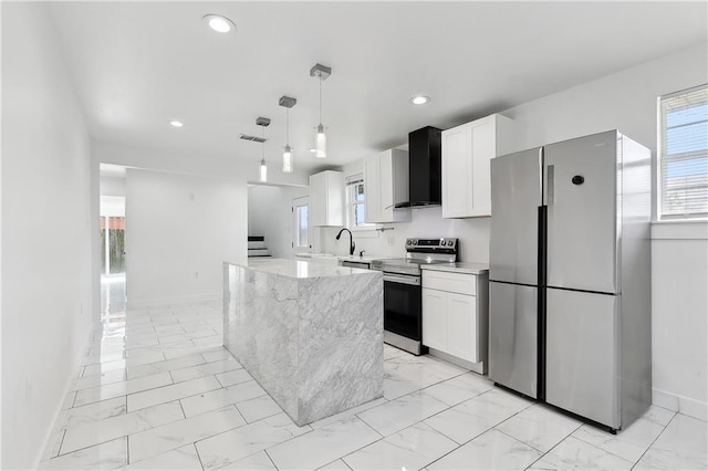 kitchen featuring marble finish floor, white cabinets, wall chimney range hood, and appliances with stainless steel finishes