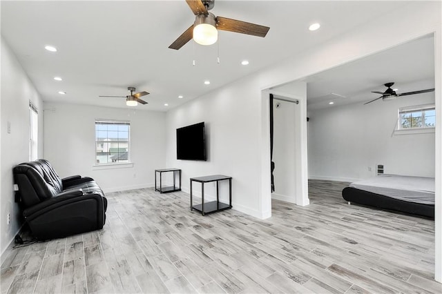 living room with ceiling fan, recessed lighting, and light wood-style floors