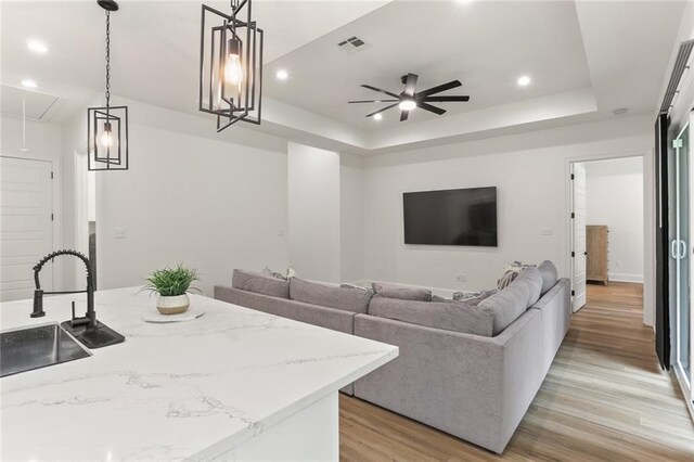185 Boutte Estates Dr, Boutte, LA 70039 - living area with a tray ceiling, attic access, ceiling fan, light wood-style flooring, and visible vents