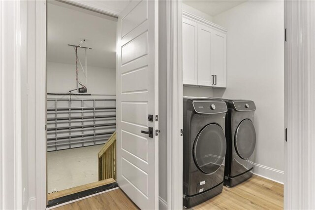 185 Boutte Estates Dr, Boutte, LA 70039 - laundry room with light wood-type flooring, washing machine and clothes dryer, and cabinet space
