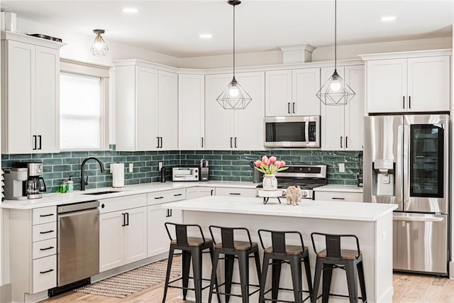41820 S Genois St, New Orleans, LA 70119 - kitchen featuring a breakfast bar area, light countertops, white cabinets, and stainless steel appliances