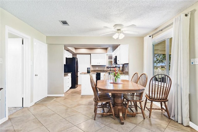 dining space with light tile patterned floors, visible vents, baseboards, and a ceiling fan