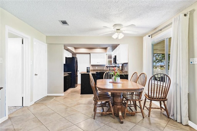 dining area featuring light tile patterned floors, visible vents, baseboards, and a ceiling fan