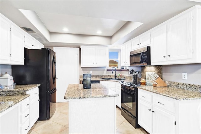 kitchen featuring a sink, a tray ceiling, white cabinetry, visible vents, and black appliances