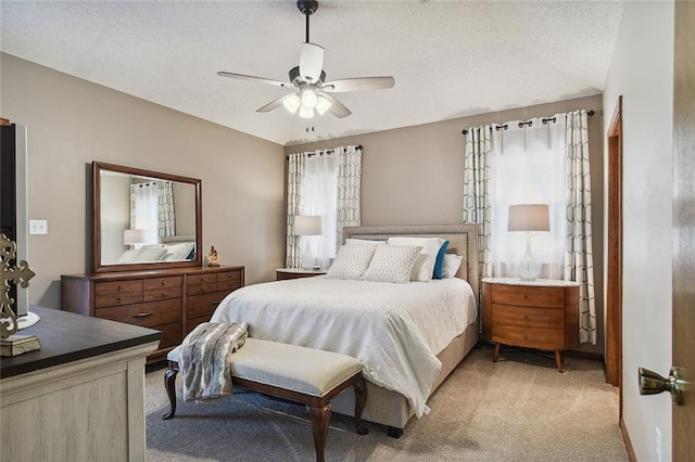 bedroom featuring light colored carpet and a ceiling fan