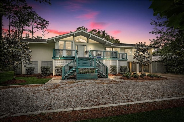 view of front of property with a porch, stucco siding, and stairway