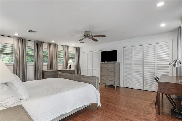 bedroom featuring ceiling fan, visible vents, wood finished floors, two closets, and recessed lighting