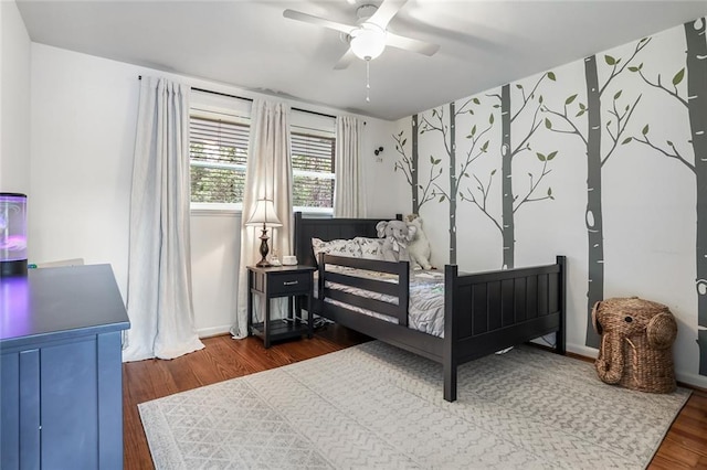 bedroom with baseboards, a ceiling fan, and wood finished floors